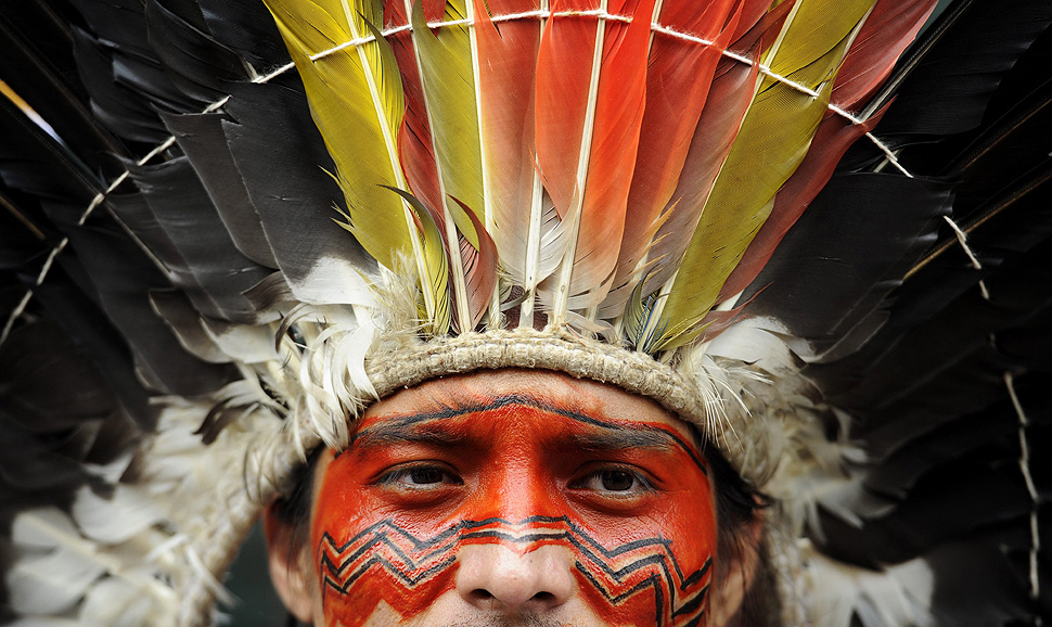 Nixiwaka Yawanawa, an Amazon Indian from Brazil, holds a placard during a demonstration outside the Brazilian Embassy in London. Worldwide protests are expected to take place this week to demand a stop to Brazil's assault on indigenous rights.