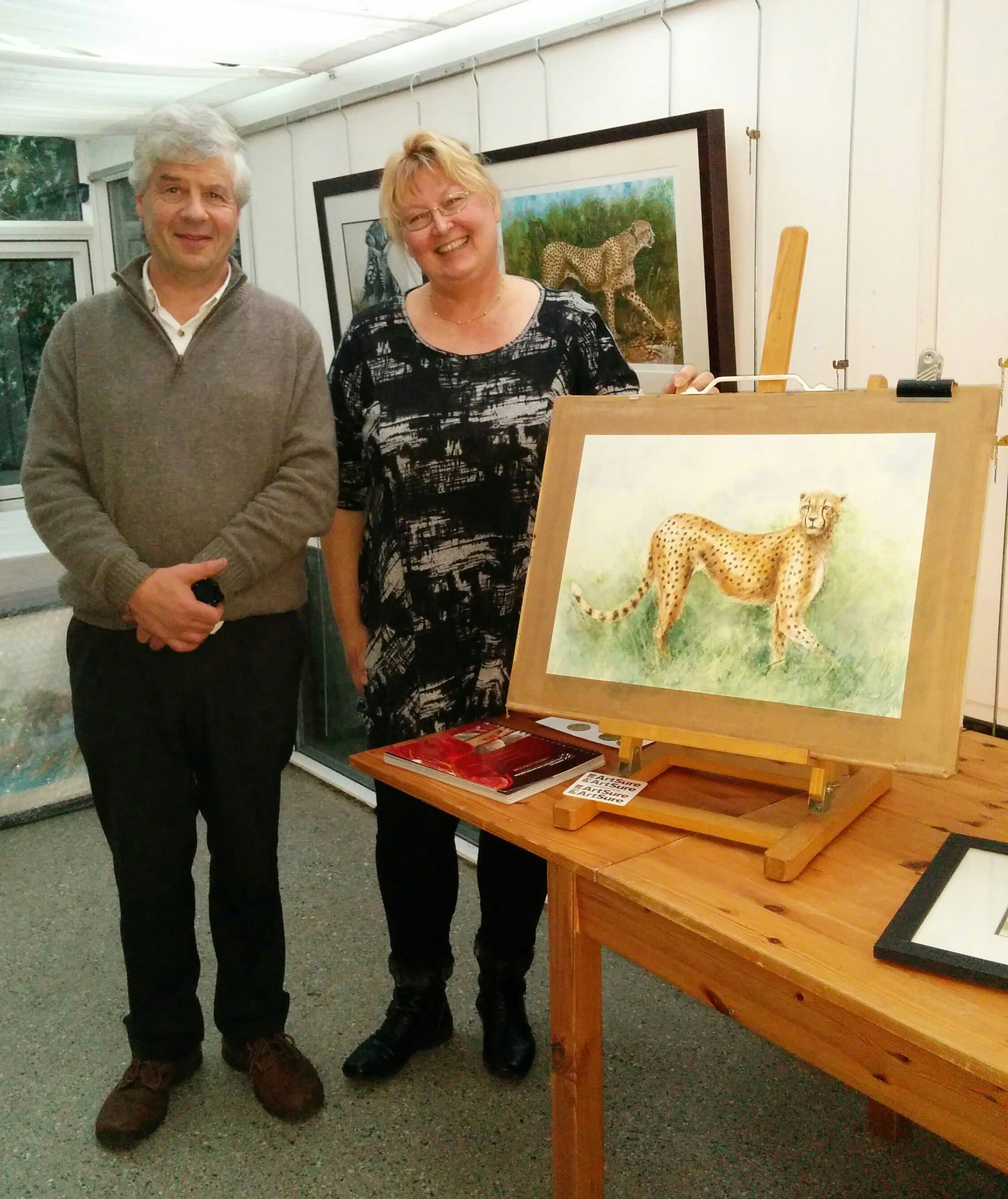 Anne says:  I am pictured here with Simon Trapnell, the Director of Nature in Art, alongside the cheetah painting (from the video) I finished off during my residency! 