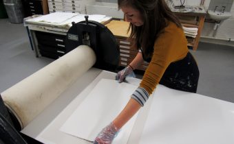 Jemma Gunning placing paper on to her inked up etching plate