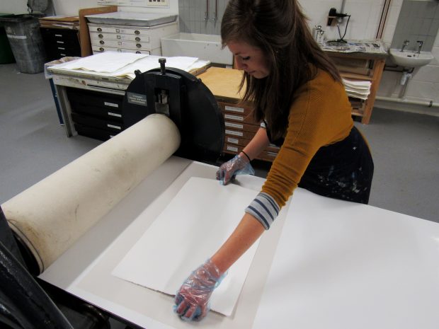 Jemma Gunning placing paper on to her inked up etching plate