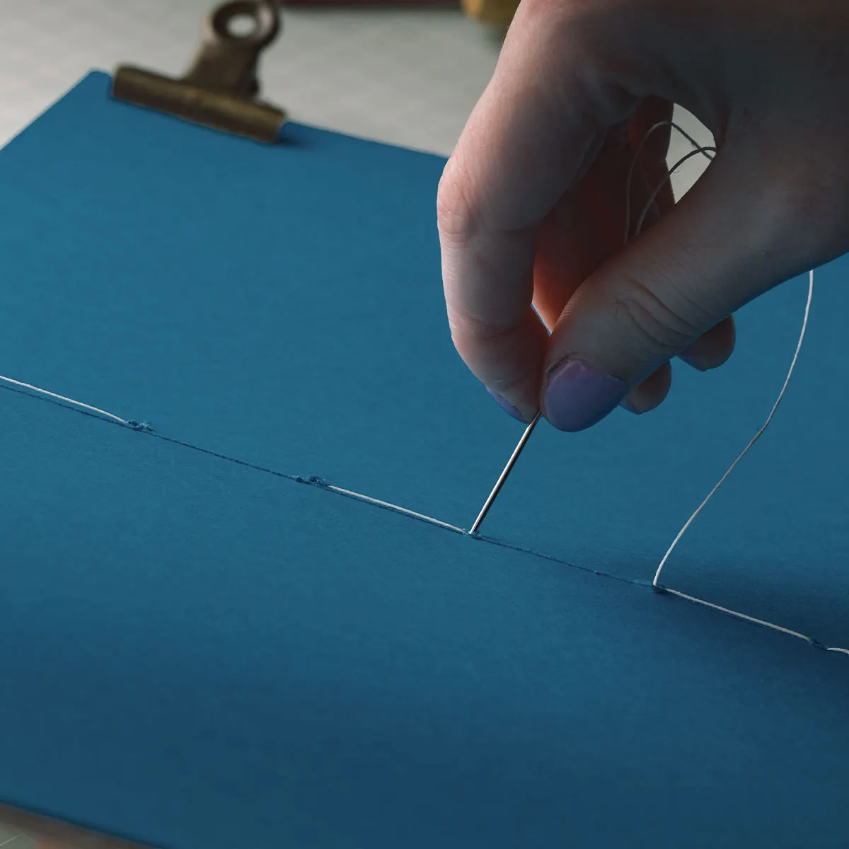 An artist Book being stitched together 