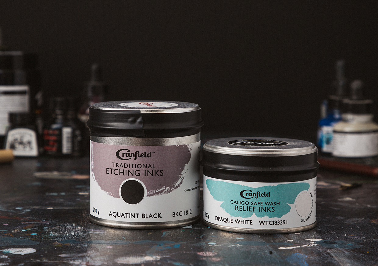 Two Relief Printmaking Inks side by side on an artist table. On left Cranfield Relief Ink and On the right Cranfield Caligo Ink