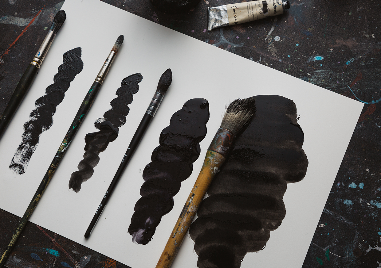 Four paint marks side by side, comparing the viscosity of oil paint, acrylic paint, artist watercolour and Indian Ink side by side on a artist paper