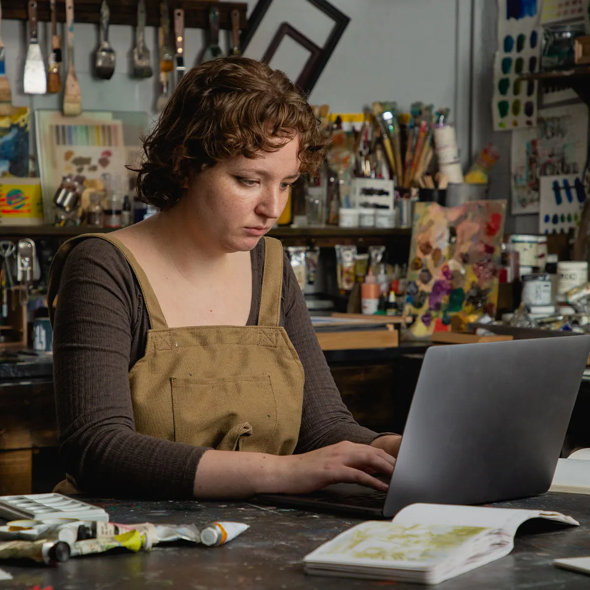 Evie Hatch, Studio and Materials Specialist typing her certificate of authenticity on her laptop