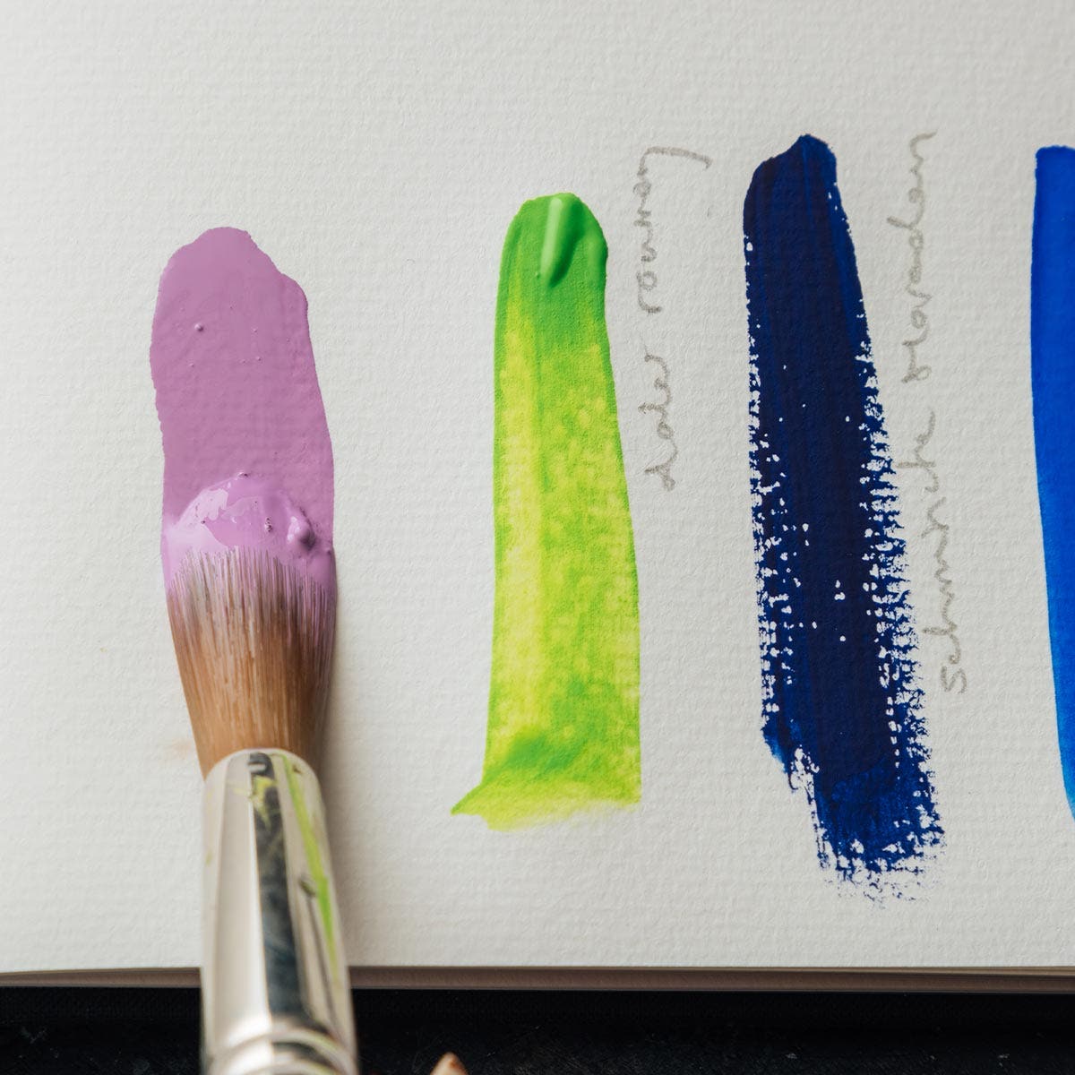 A selection of different gouache paint painted on an artist paper