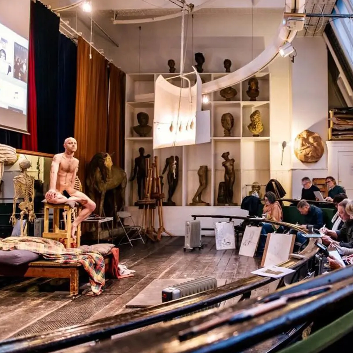 Life drawing model posing for a group of artists