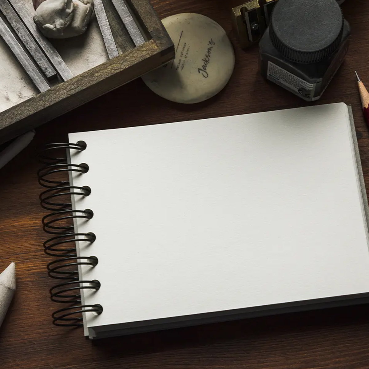 Sketchbooks and life drawing materials on a studio table